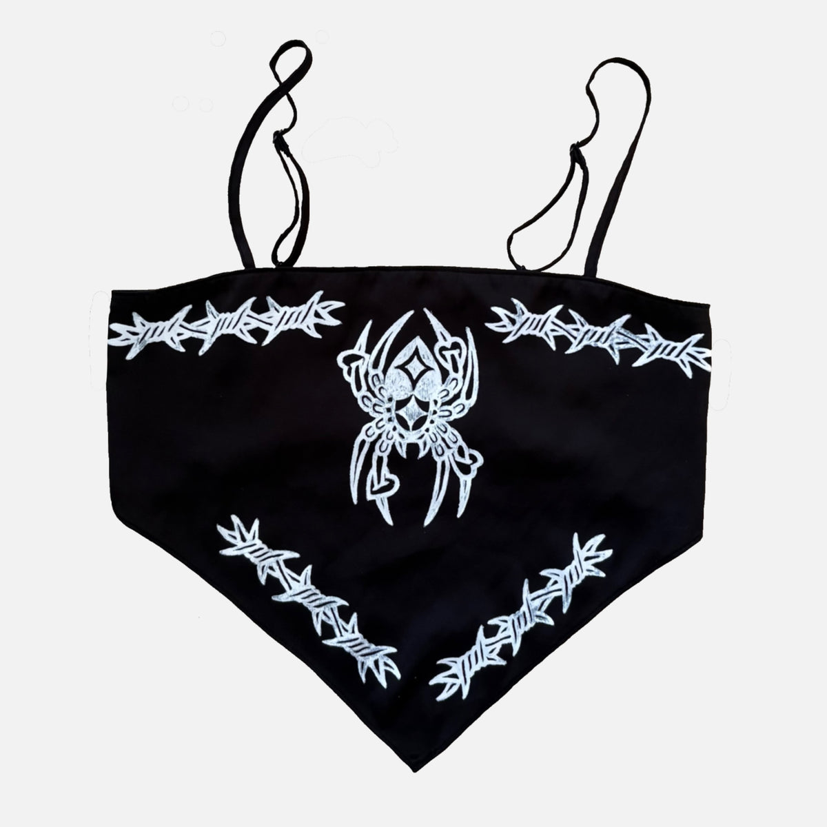 Black triangle crop top with white barbed wire graphics and a central spider design, featuring thin black shoulder straps, shown against a light gray background.
