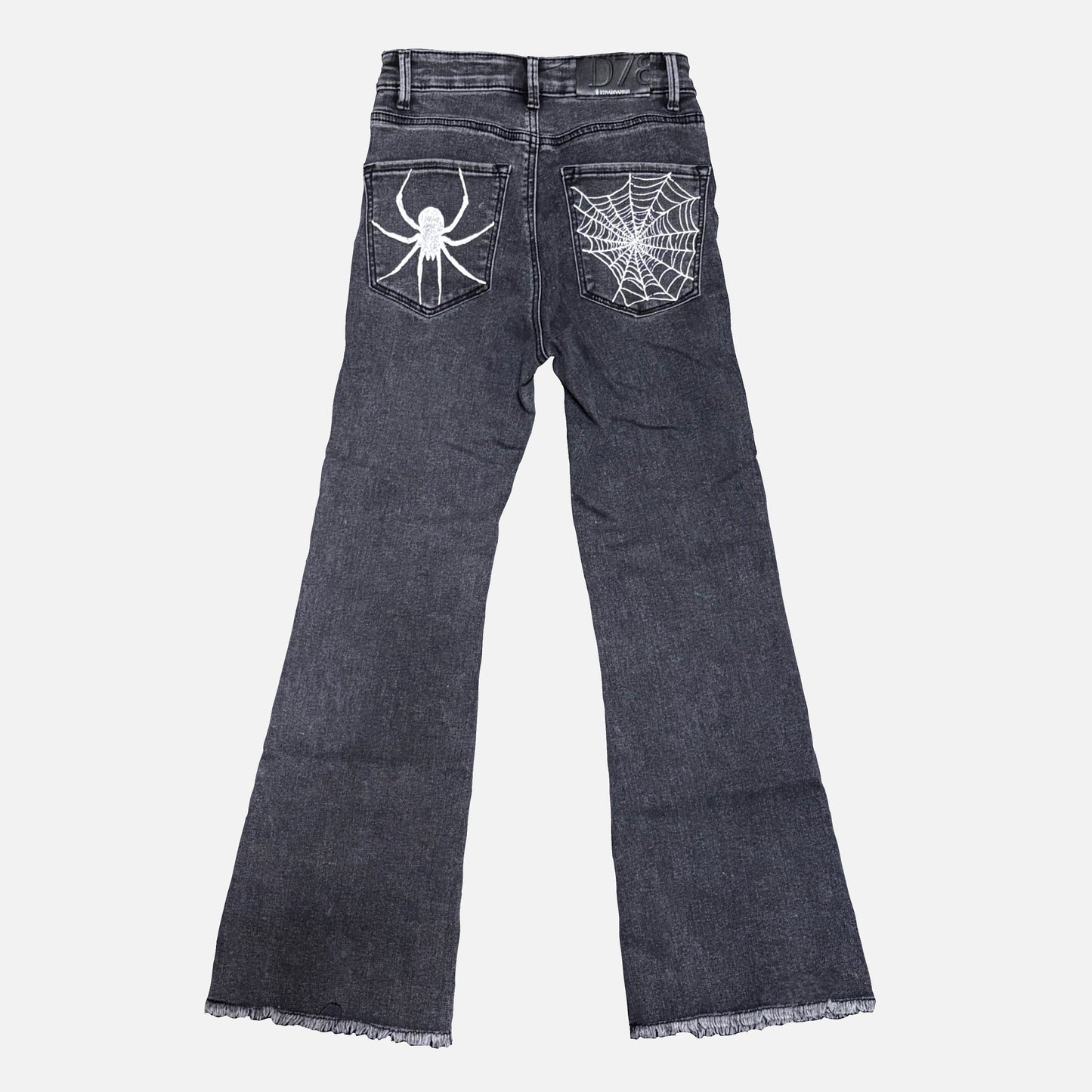 Dark gray denim jeans shown from the back, featuring a white spider graphic on the right back pocket and a white spiderweb design on the left back pocket, with frayed hems.