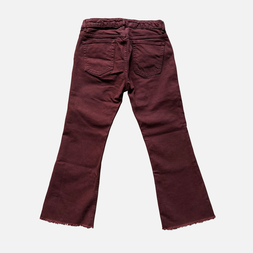 A pair of dark burgundy flare jeans shown from the back, featuring a drawstring waistband, two back pockets, and a raw frayed hem, set against a plain light gray background.