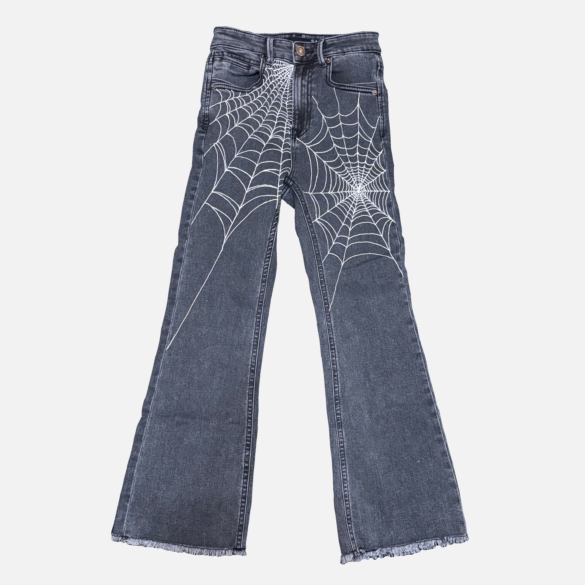 Dark gray denim jeans with white spiderweb patterns printed across the front of both legs, shown against a light gray background.